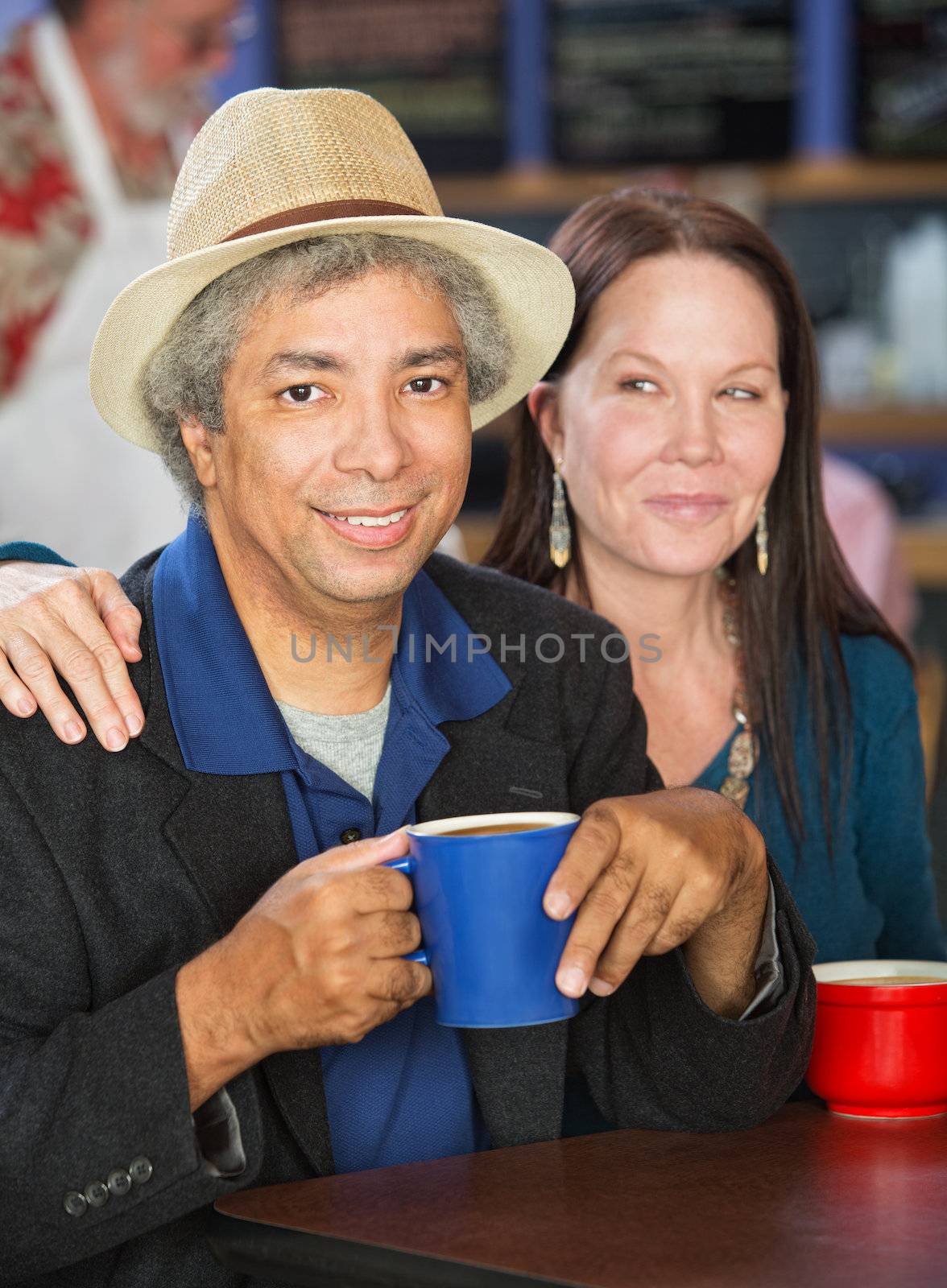 Smiling mixed couple together in coffee house