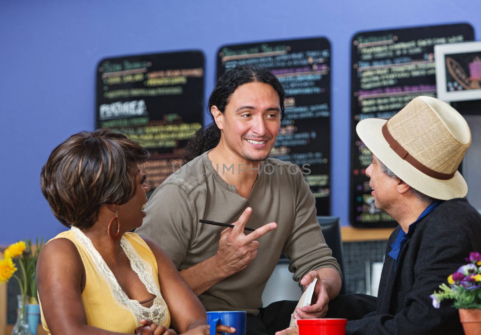 Handsome cafe owner with diverse customers taking orders