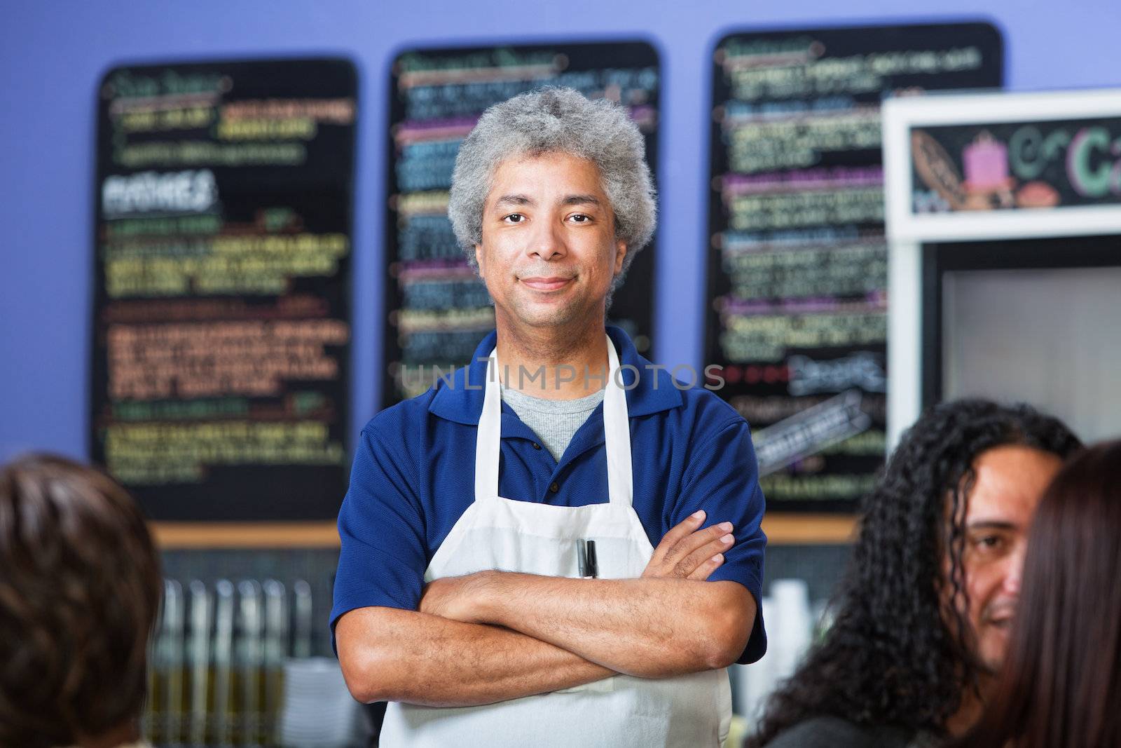 Man with folded arms standing in a coffee house