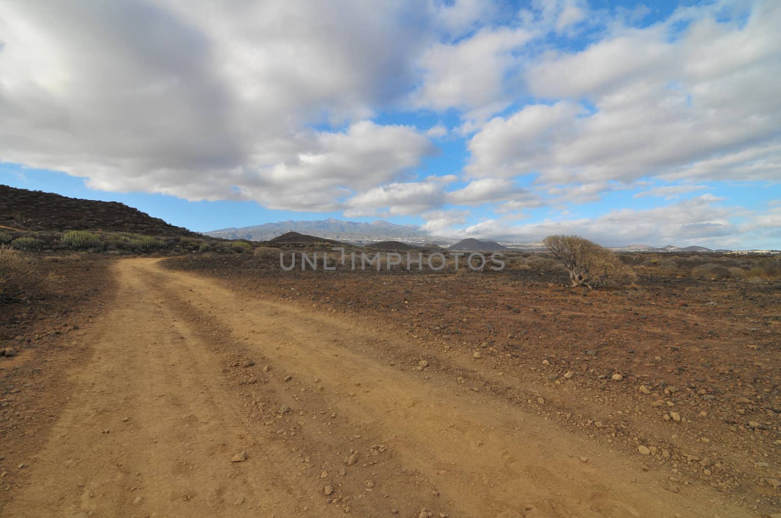 Sand and Rocks Road in the Desert on a Cloudy Sky