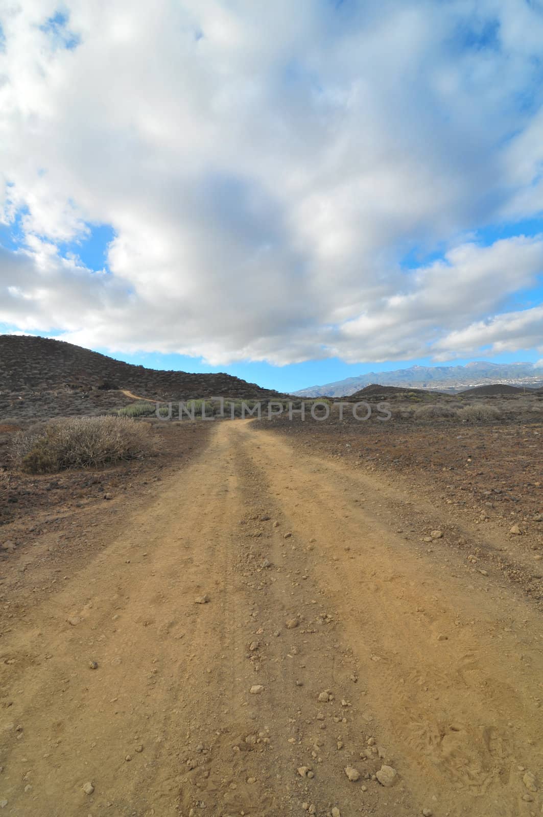 Sand and Rocks Road in the Desert on a Cloudy Sky