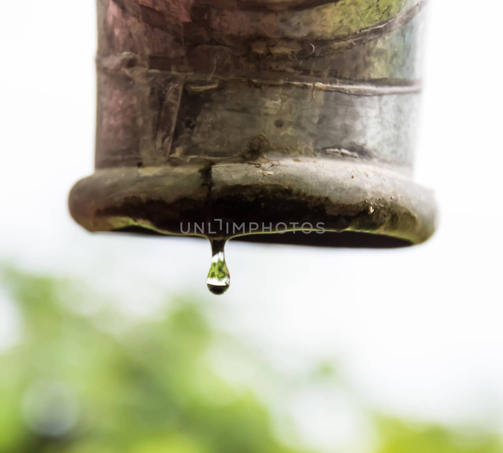 Water drips from a pipe. by photo2life