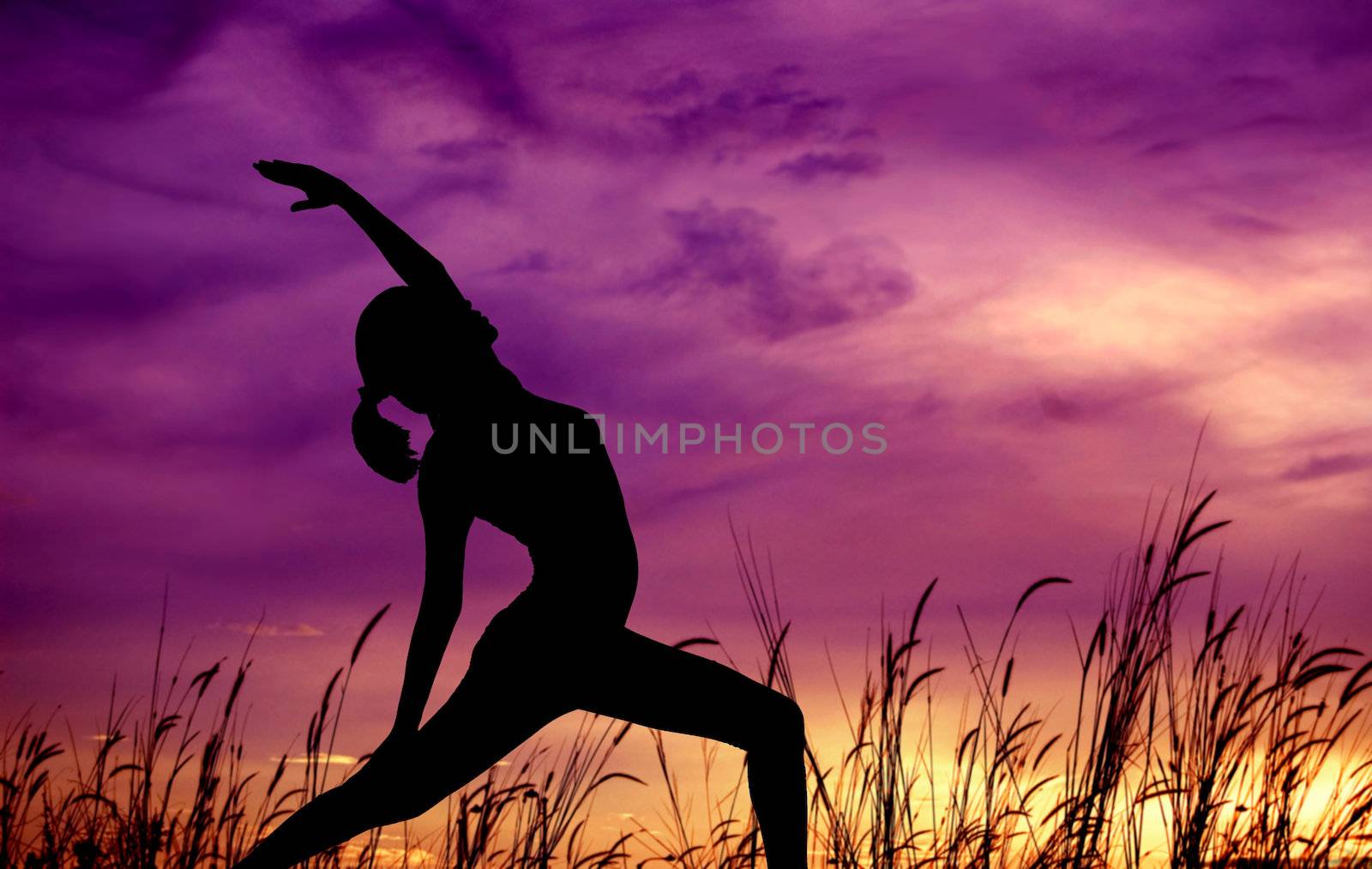 Silhouette of young woman doing yoga at outdoor park.