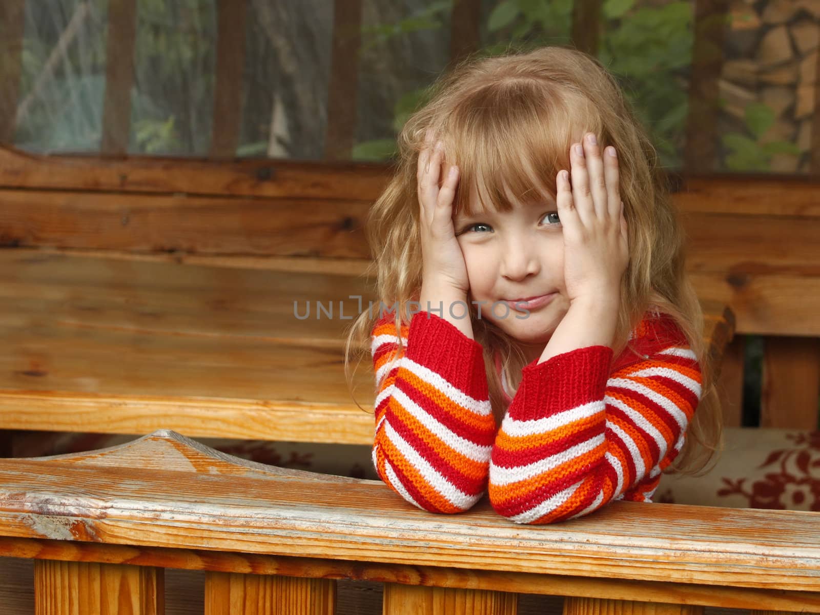 Little beautiful Caucasian girl in summer wooden canopy outdoor