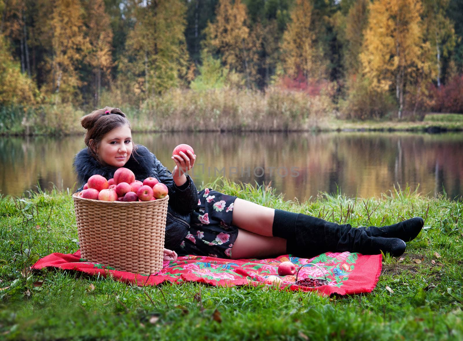 haughty woman with a basket of apples on a picnic