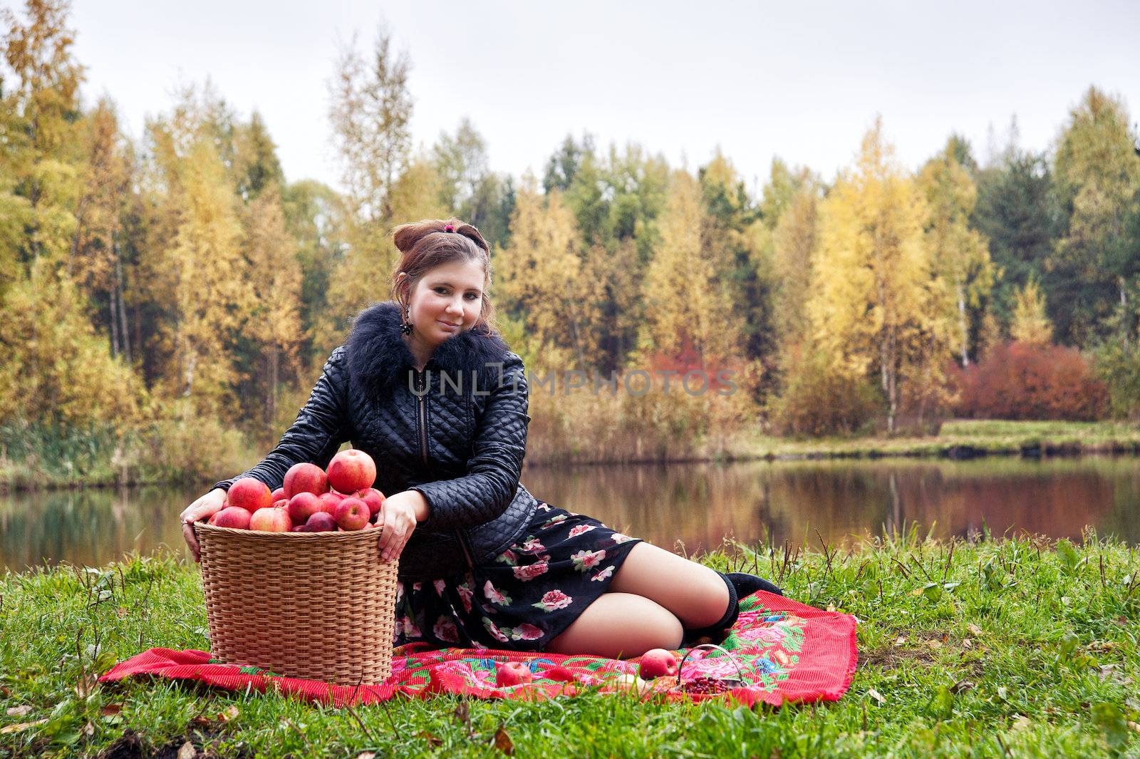 haughty woman with a basket of apples on a picnic