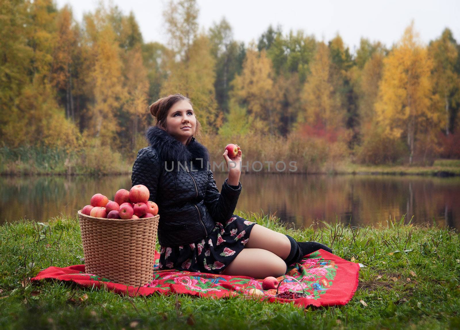 haughty woman with a basket of apples on a picnic