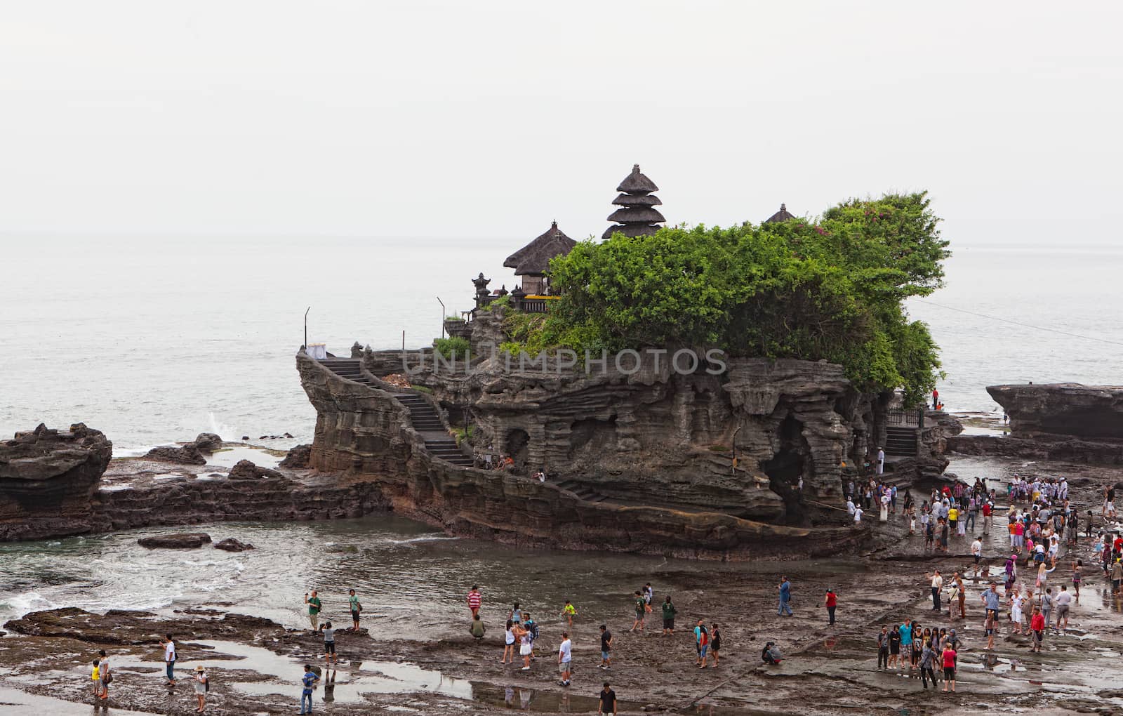Tourists on an ocean coast near the temple Tana Lot, Bali, Indonesia 11.03.2012. Tanah Lot is one of the most important sea temples of Bali