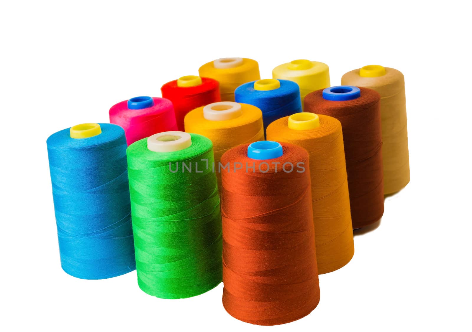 Colored fine thread bobbins on white