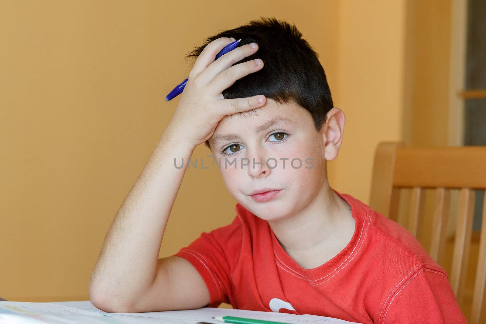 boy doing school homework, is tired and bored