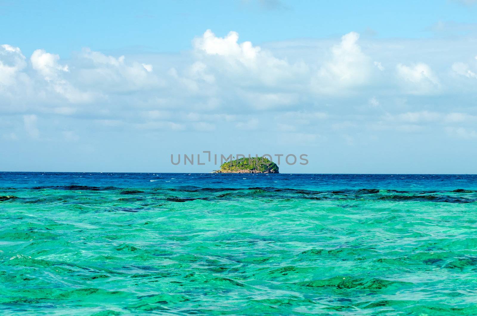 Small green island on the horizon of the Caribbean Sea near San Andres y Providencia, Colombia