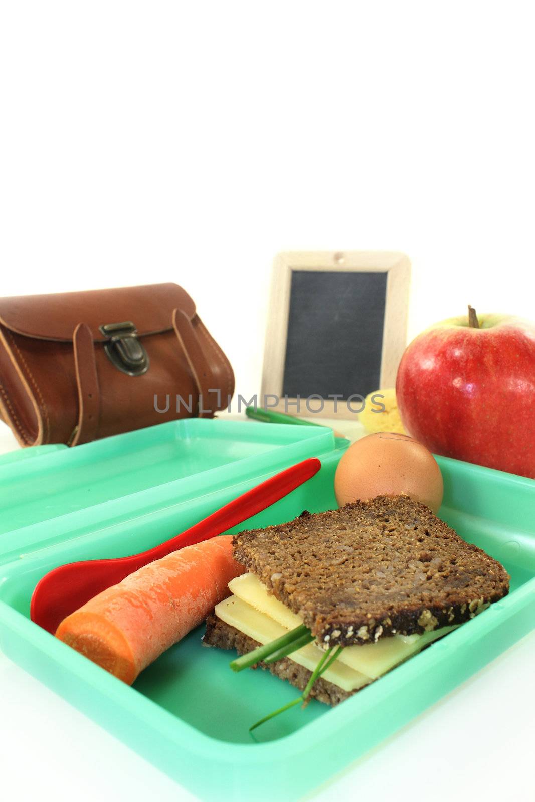 a lunch box with a busy slice of bread and a carrot and an apple
