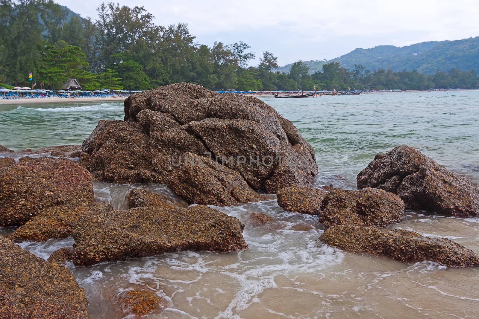 View through rocks on coastline of beach of sea,Thailand .