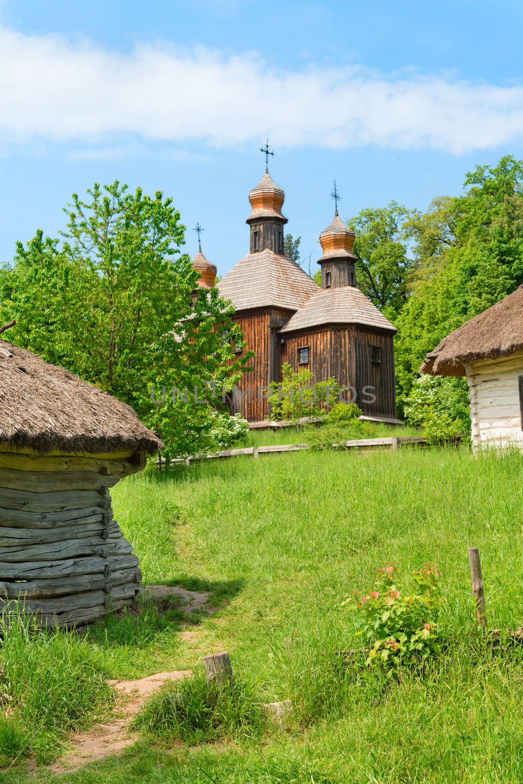 Vintage wooden church on green country under blue sky