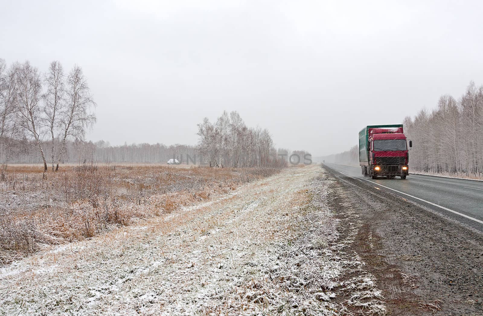 View of  truck on winter road against  cloudy sky.