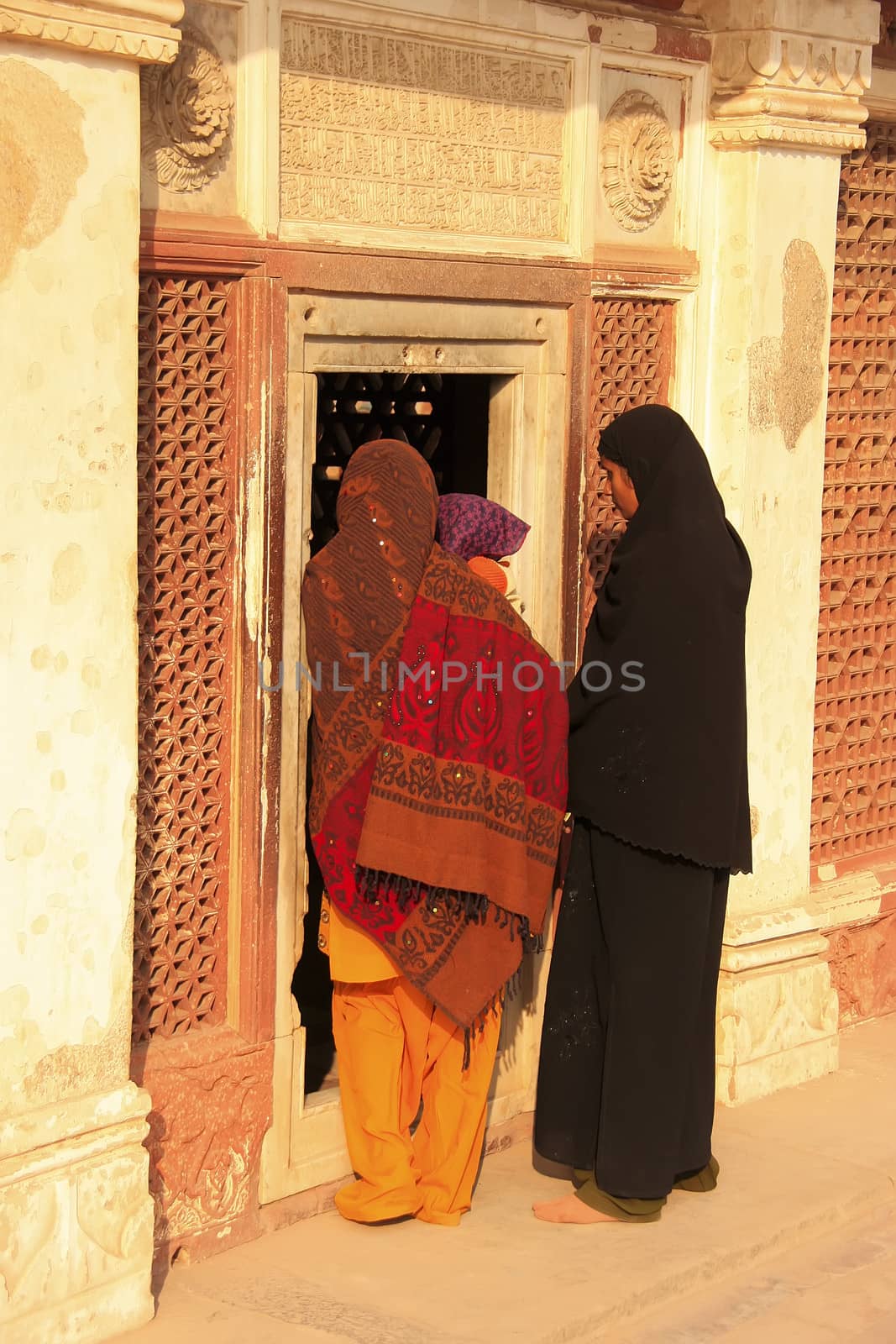 Indian women standing by the door at Qutub Minar complex, Delhi, India