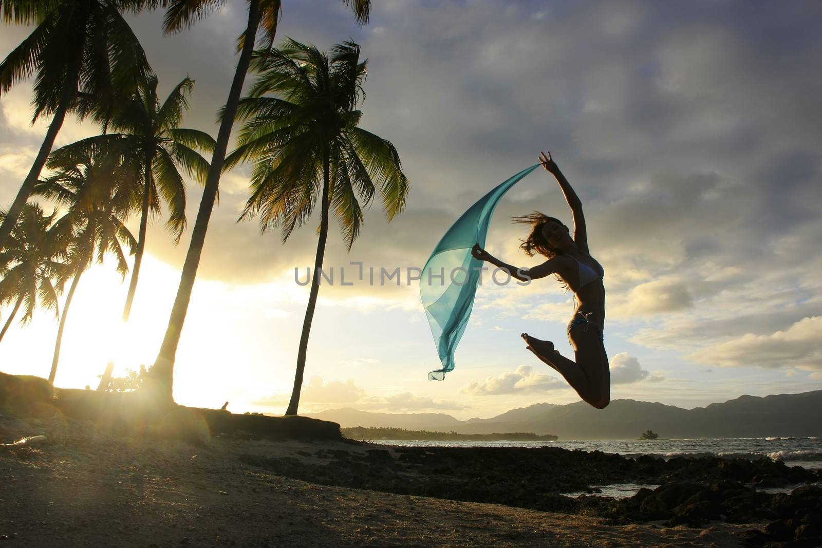 Silhouette of young woman jumping at Las Galeras beach, Samana peninsula, Dominican Republic