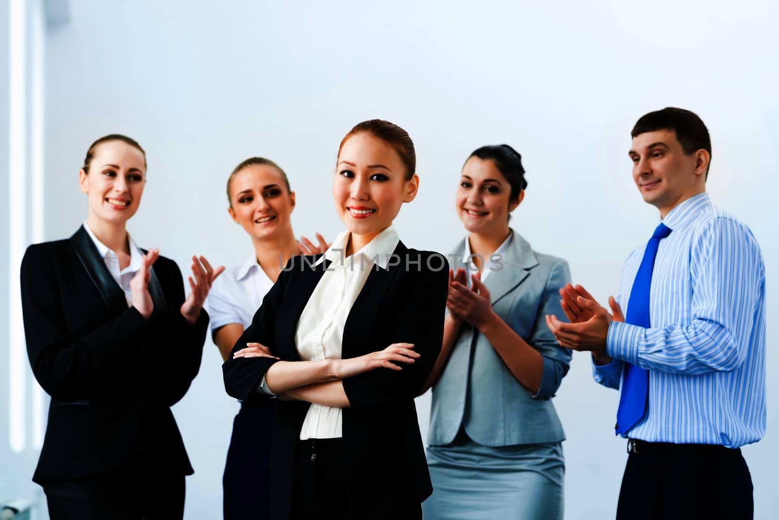 successful business woman in the office, around applauding colleagues