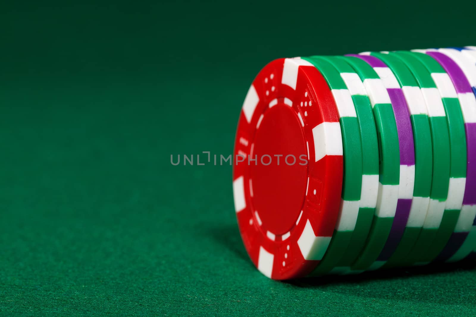 Colorful poker chips closeup on green cloth