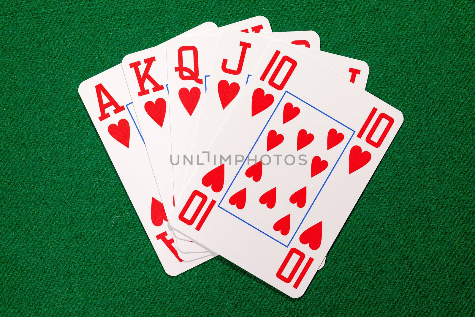 Poker cards with royal flush combination on green cloth