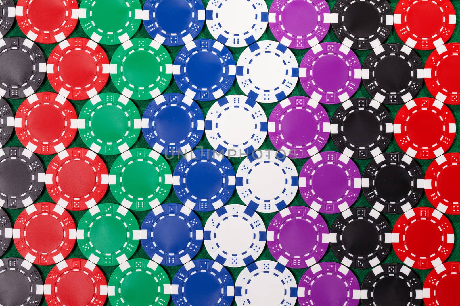 Colorful poker chips closeup on green cloth, backdrop