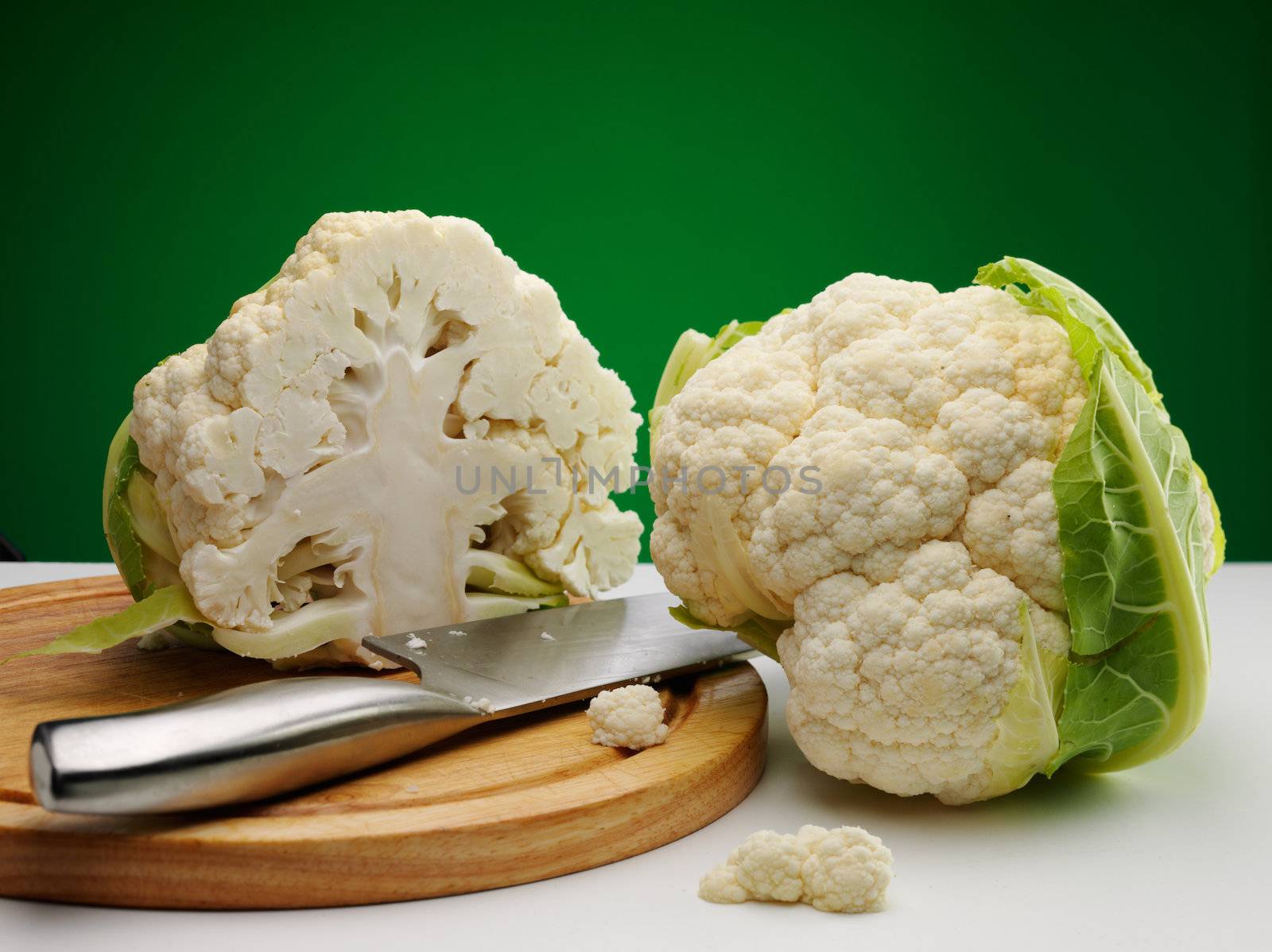 ripe cauliflower on the table over green background