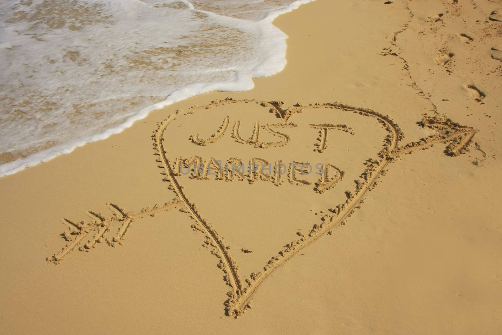 "Just married" written in sand on a beach by donya_nedomam