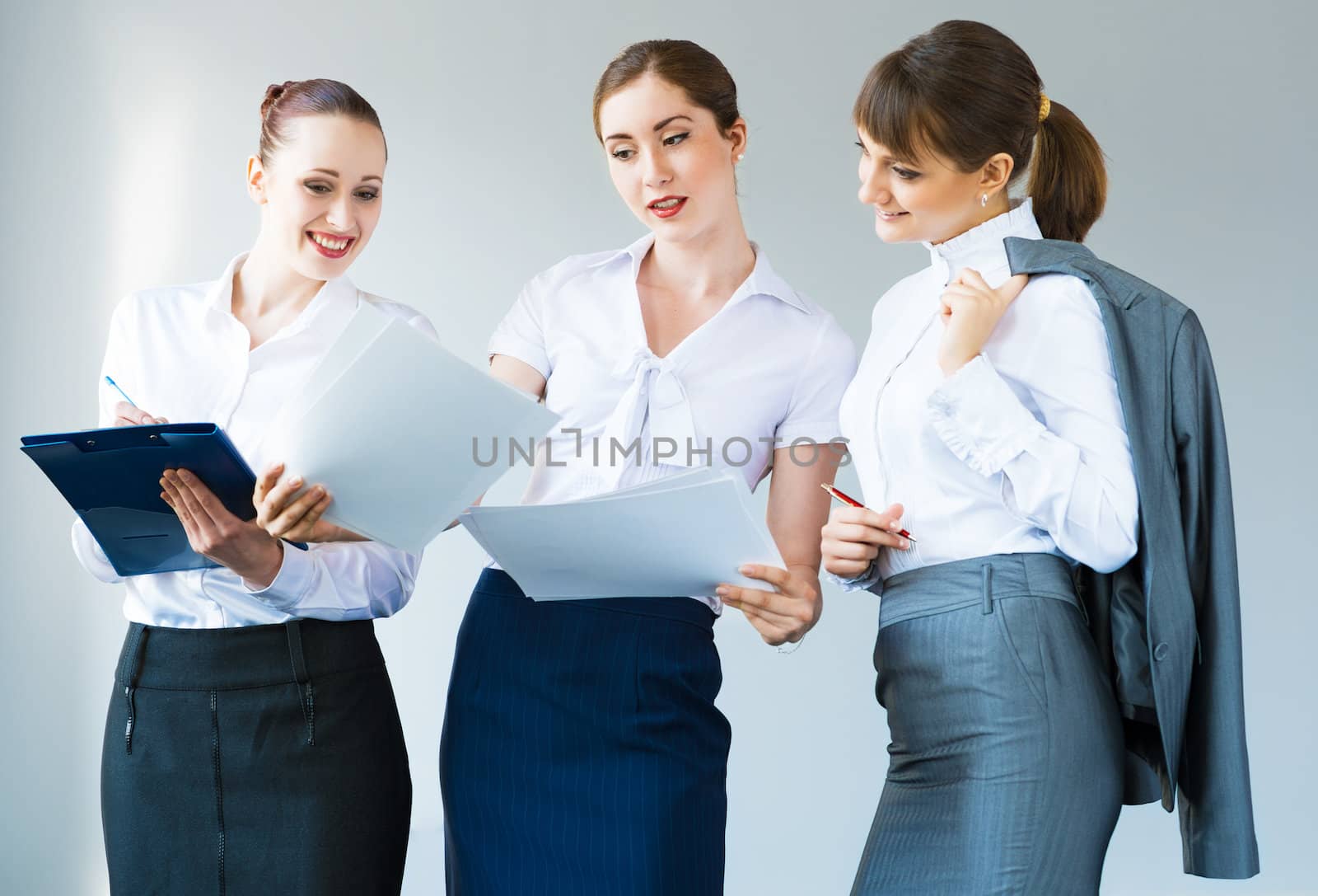 group of business women discussing documents together, teamwork in business
