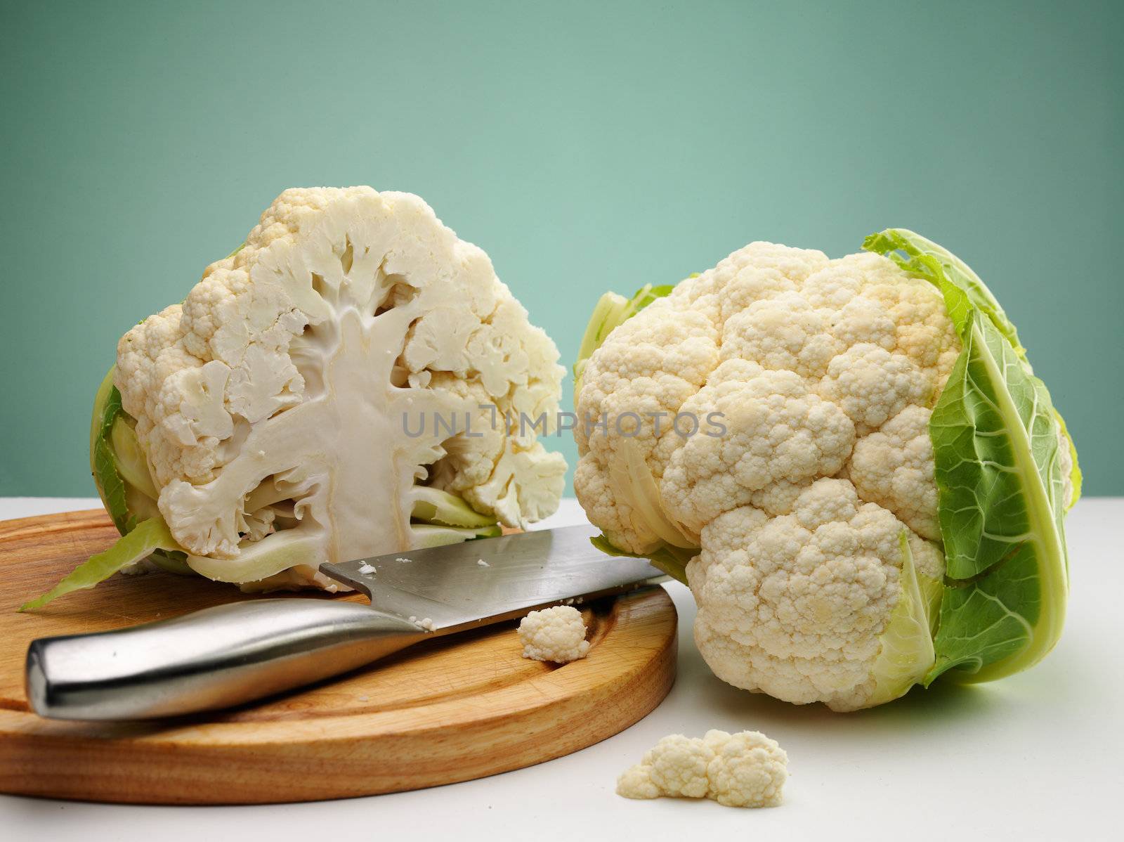 ripe cauliflower on the table over green background