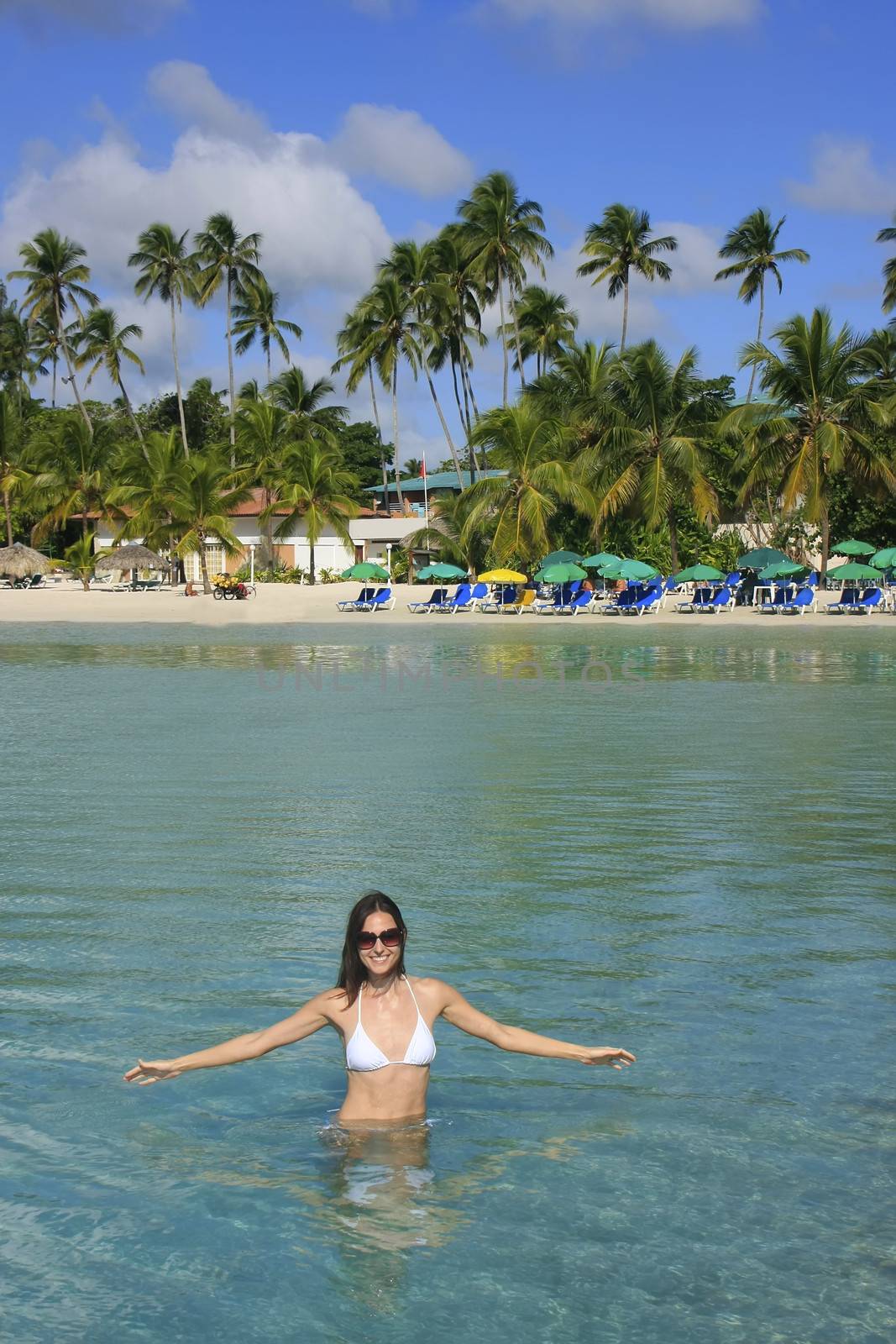 Young woman in bikini standing in clear water, Boca Chica beach, Dominican Republic