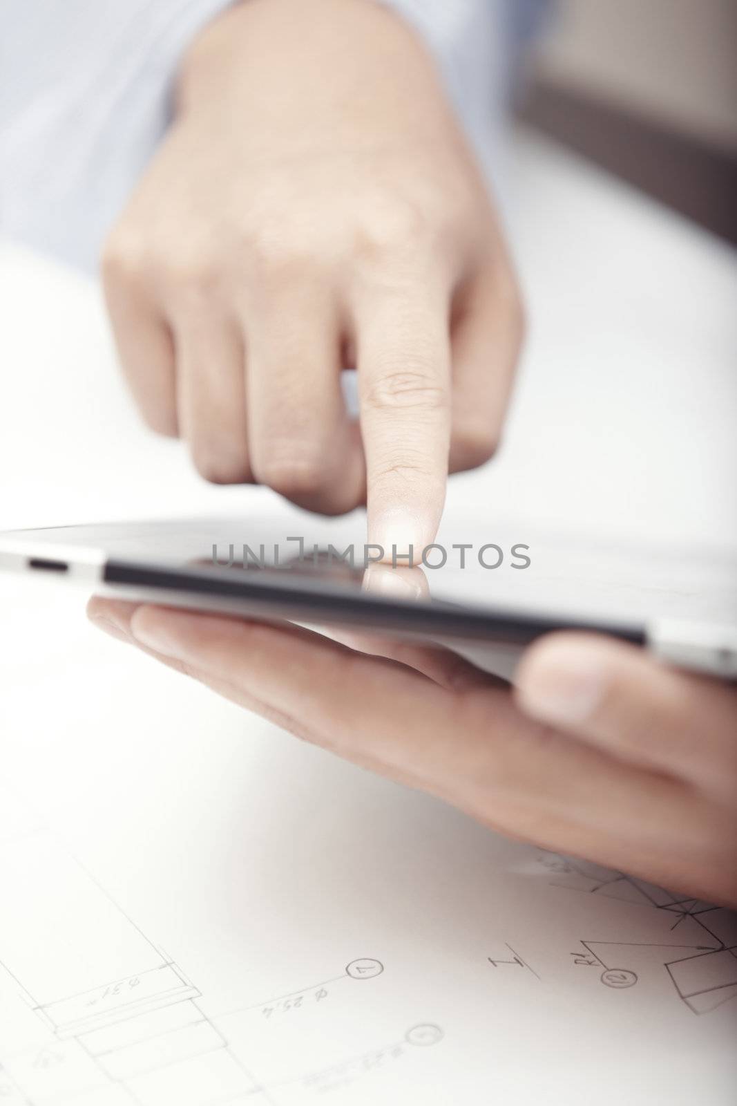 Hands of businessman using tablet PC at office