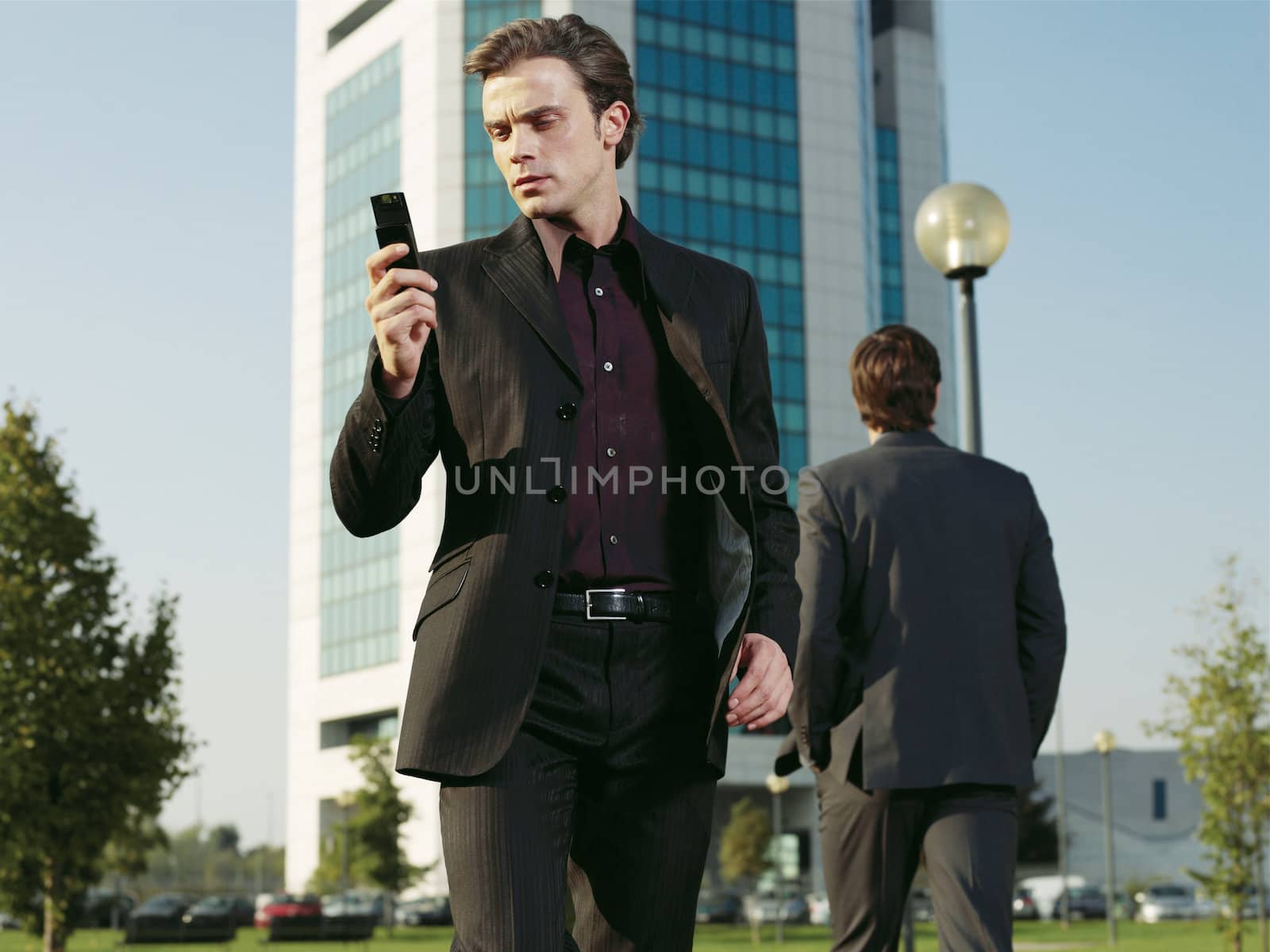 Businessman working near office with mobie phone