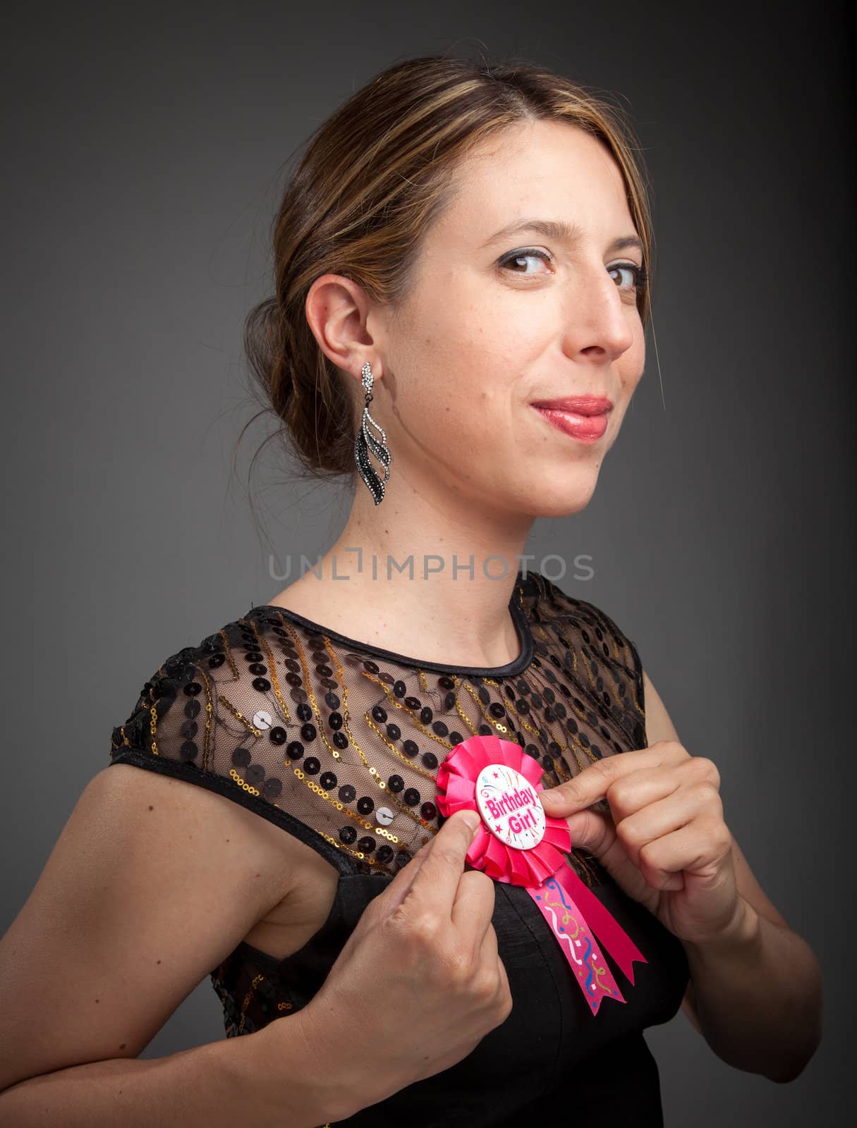 Attractive caucasion girl wearing an evening gown in her 30s shot in studio isolated on a grey background