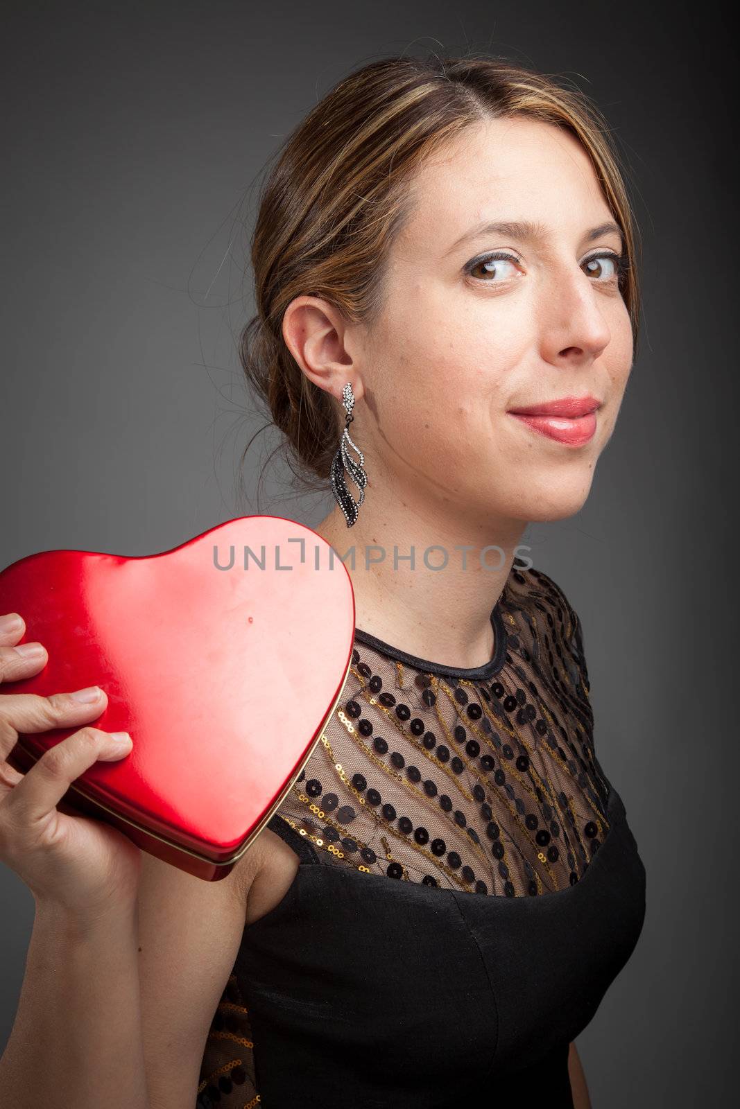 Attractive caucasion girl wearing an evening gown in her 30s shot in studio isolated on a grey background