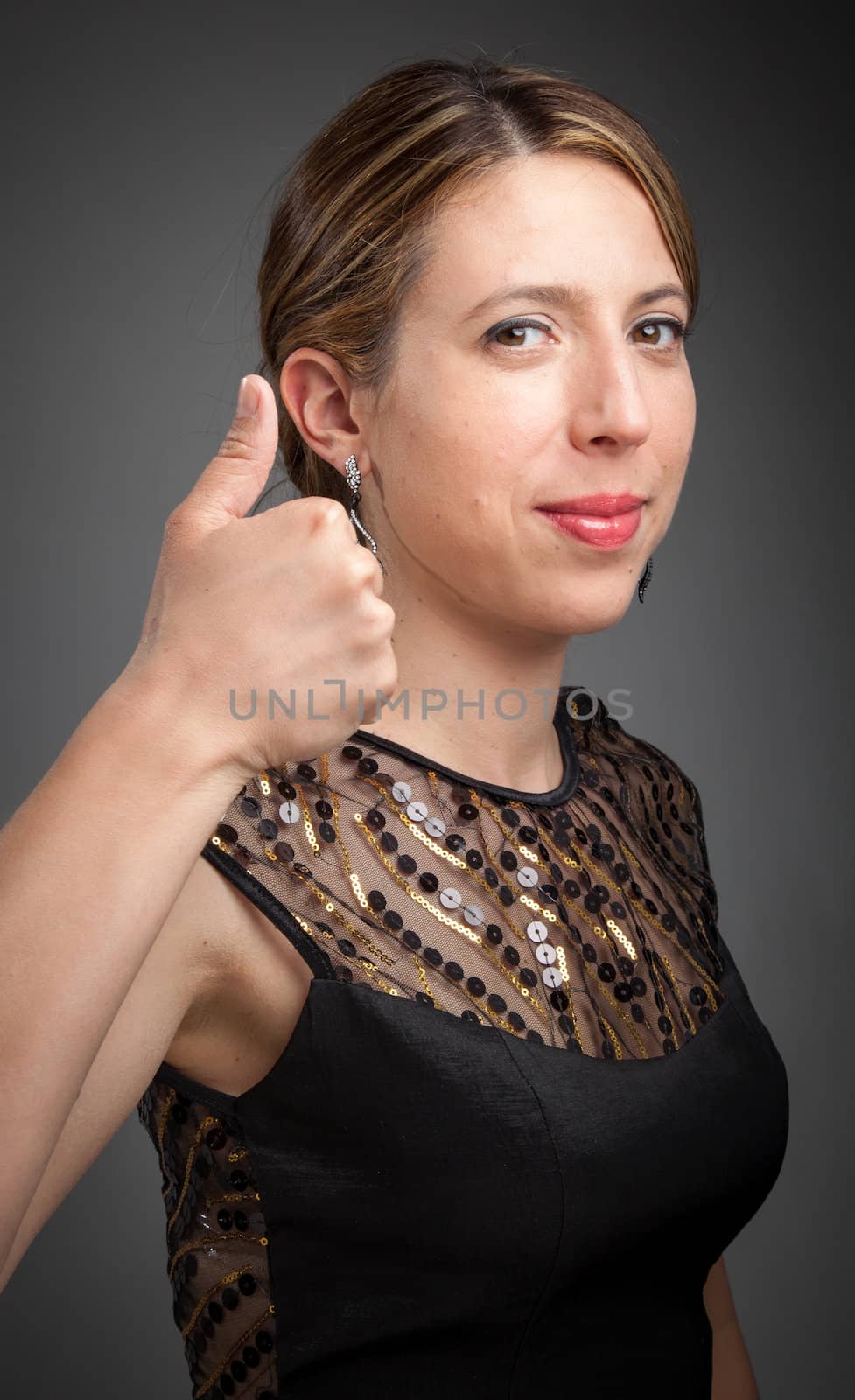 Attractive caucasion girl wearing an evening gown in her 30s shot in studio isolated on a grey background