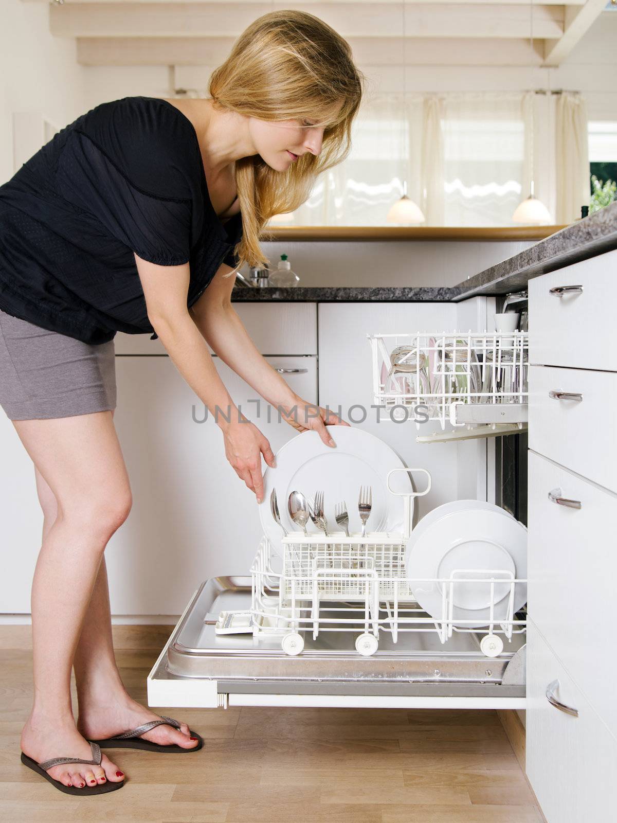 Female emptying the dishwasher by sumners