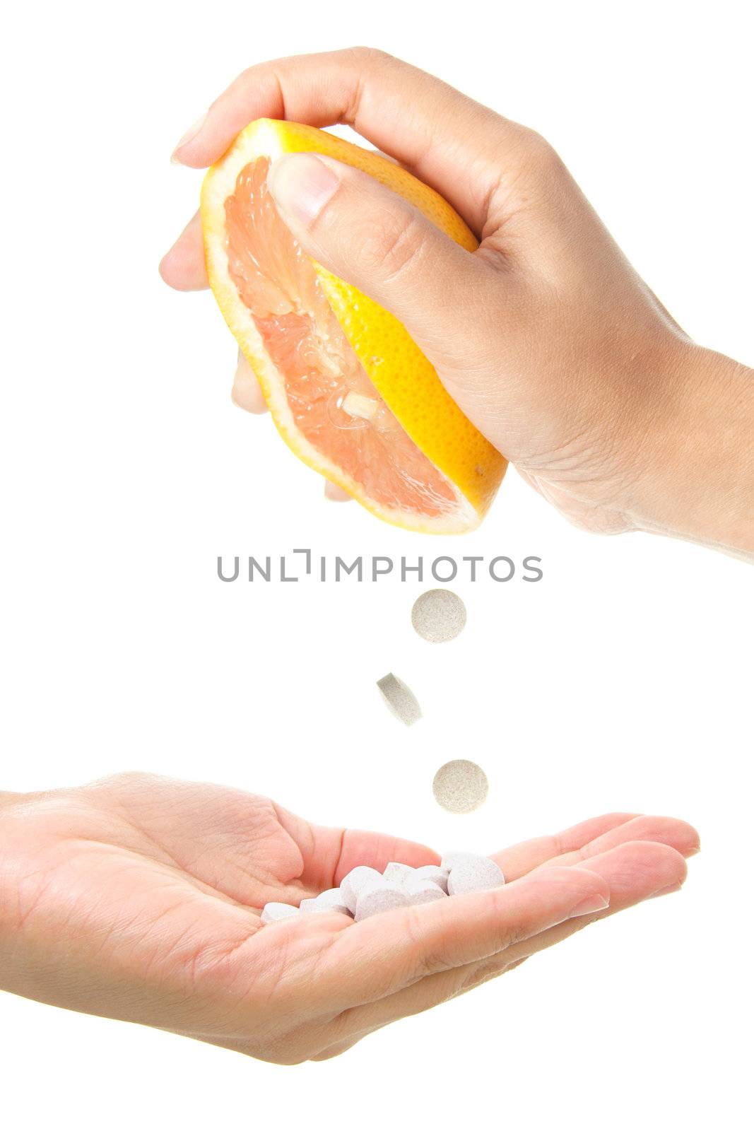 Conceptual image of vitamin tablets being squeezed out of a grapefruit