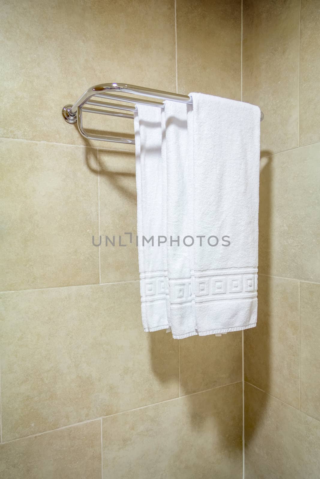 White bath towels hanging on a rack by doble.d