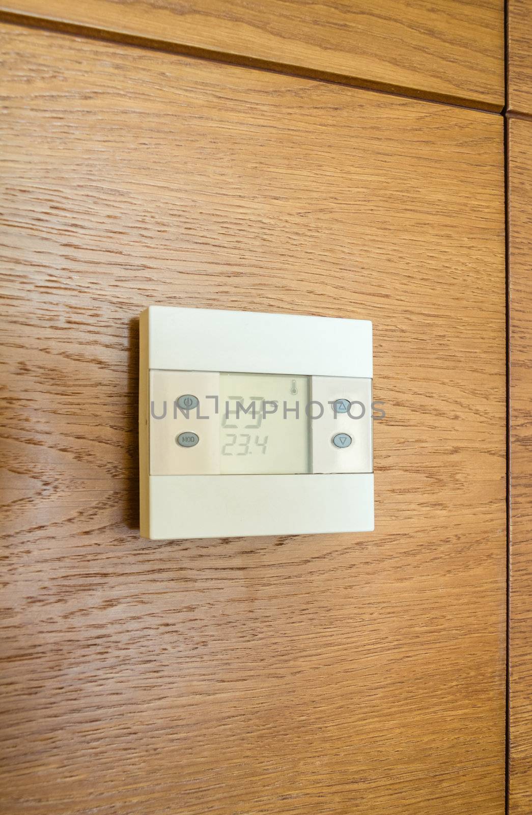Digital thermostat panel on wooden wall by doble.d