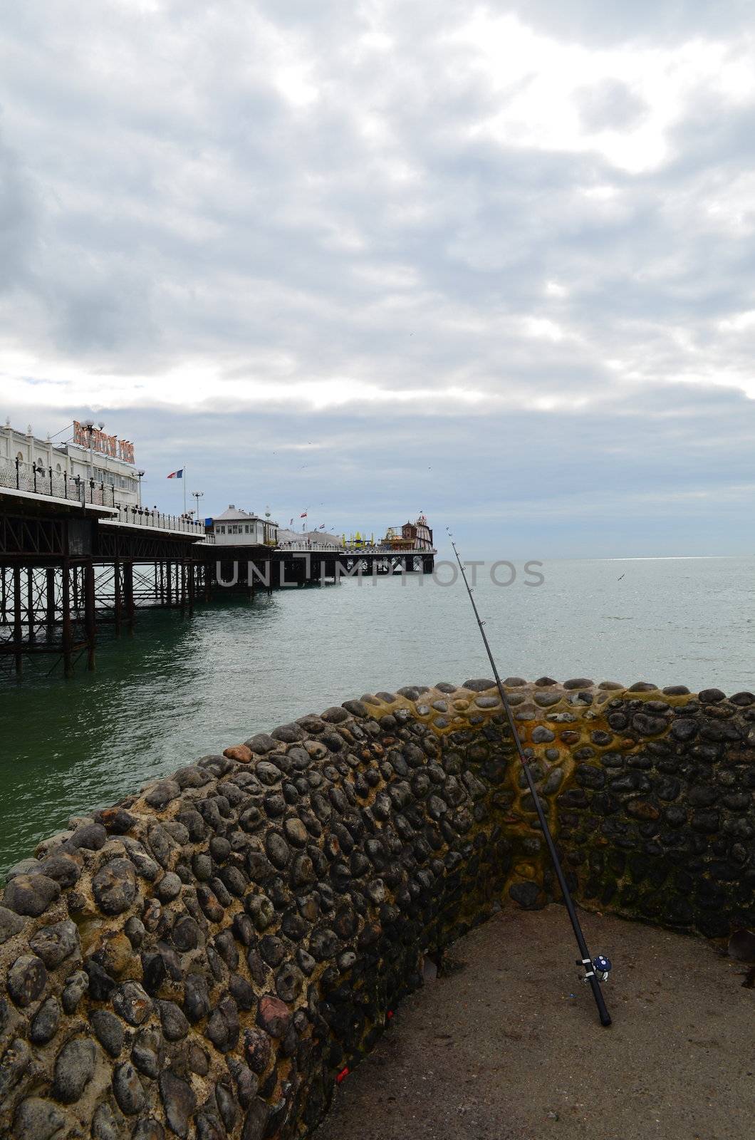 Signal fishing rod resting against a harbour wall with Brighton pier in the foreground.