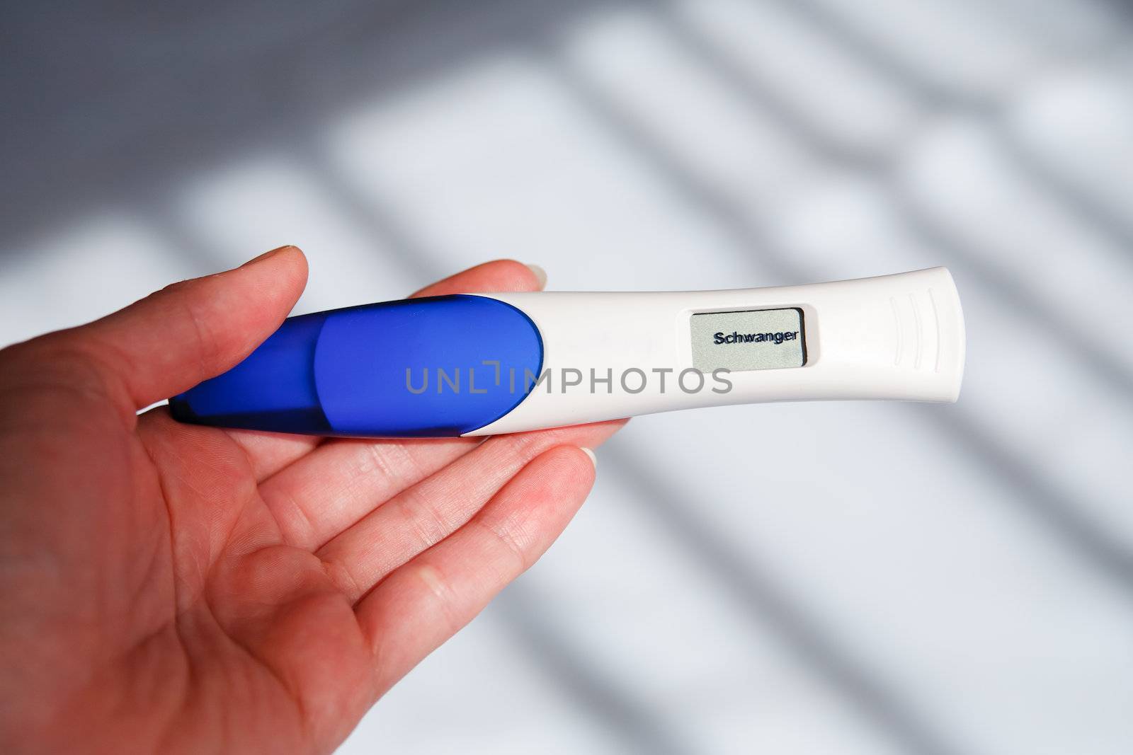 Woman taking a pregnancy test showing pregnant result