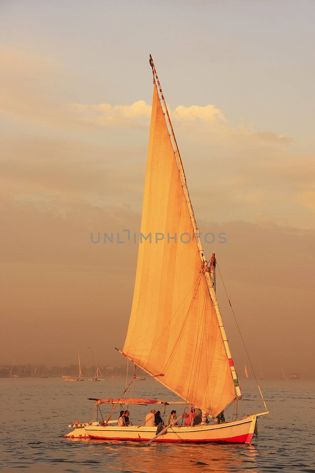 Felucca boat sailing on the Nile river at sunset, Luxor, Egypt