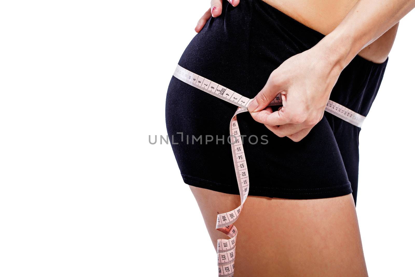 Girl measuring hip circumference after a grueling workout, isolated on white background