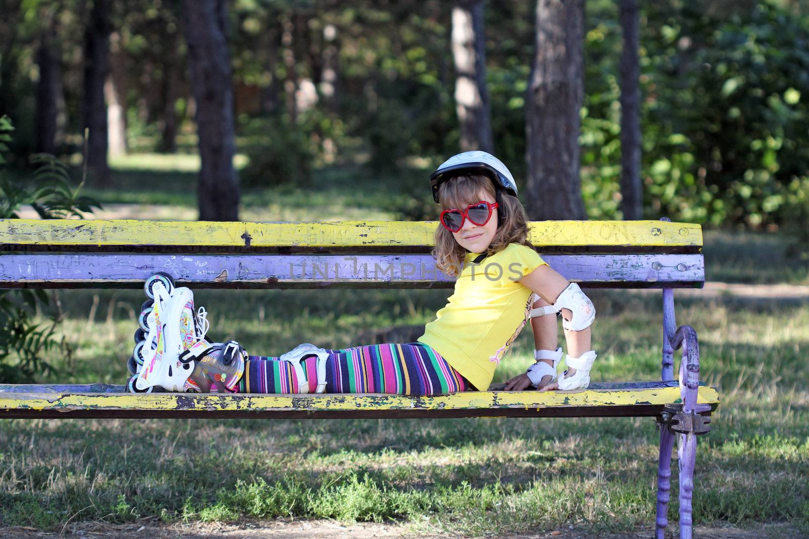 little girl with roller skates in park by goce