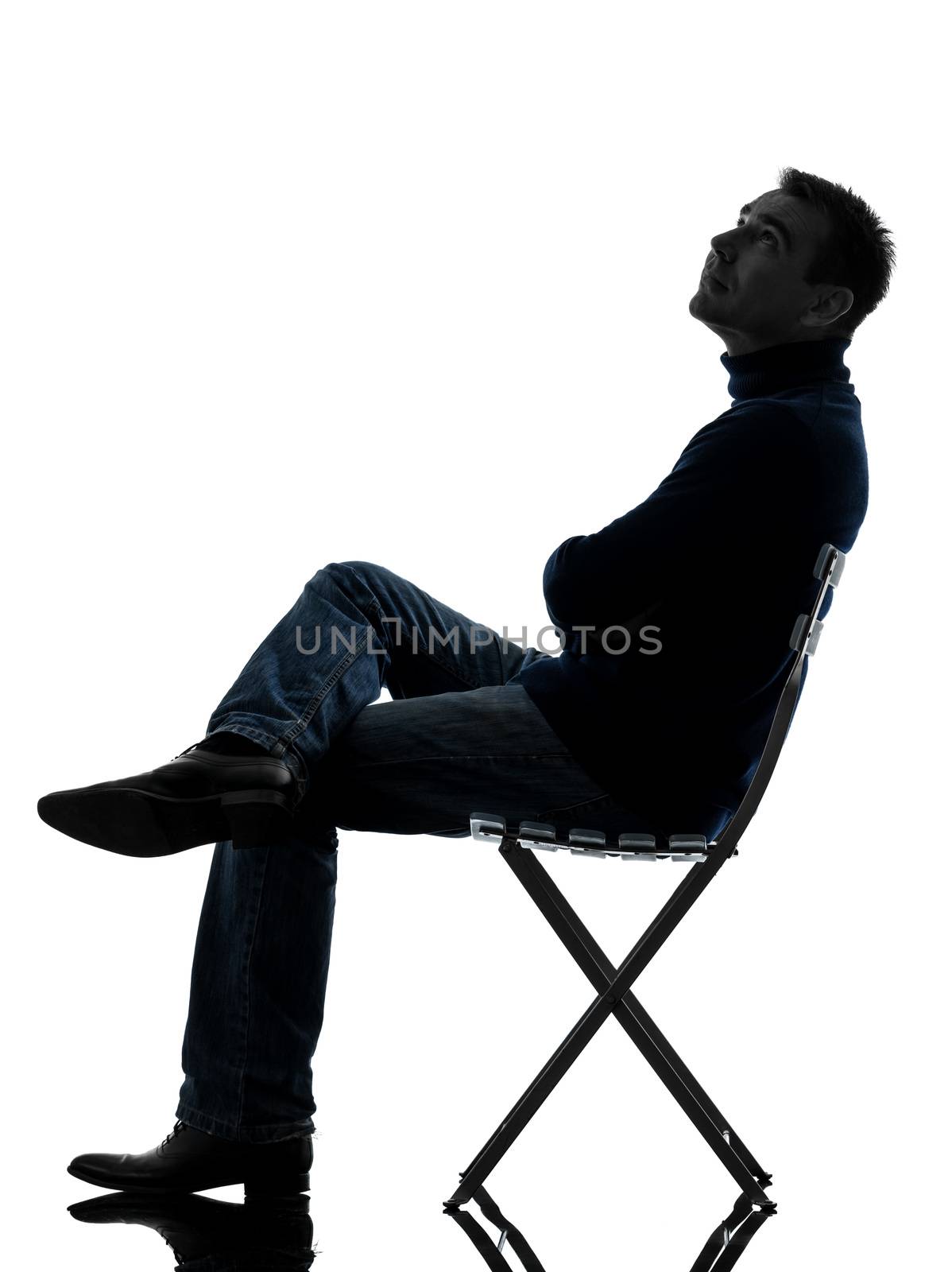 one caucasian man sitting looking up   full length in silhouette studio isolated on white background