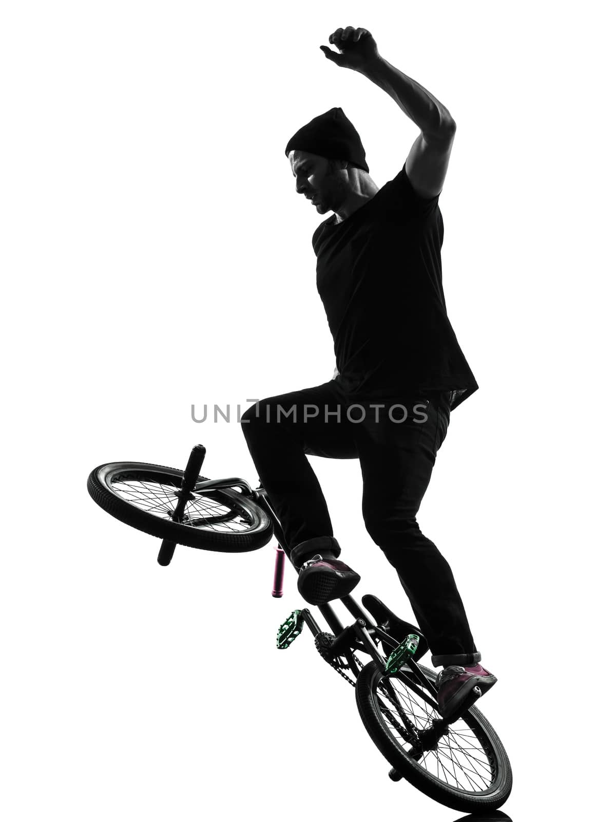 one caucasian man exercising bmx acrobatic figure in silhouette studio isolated on white background