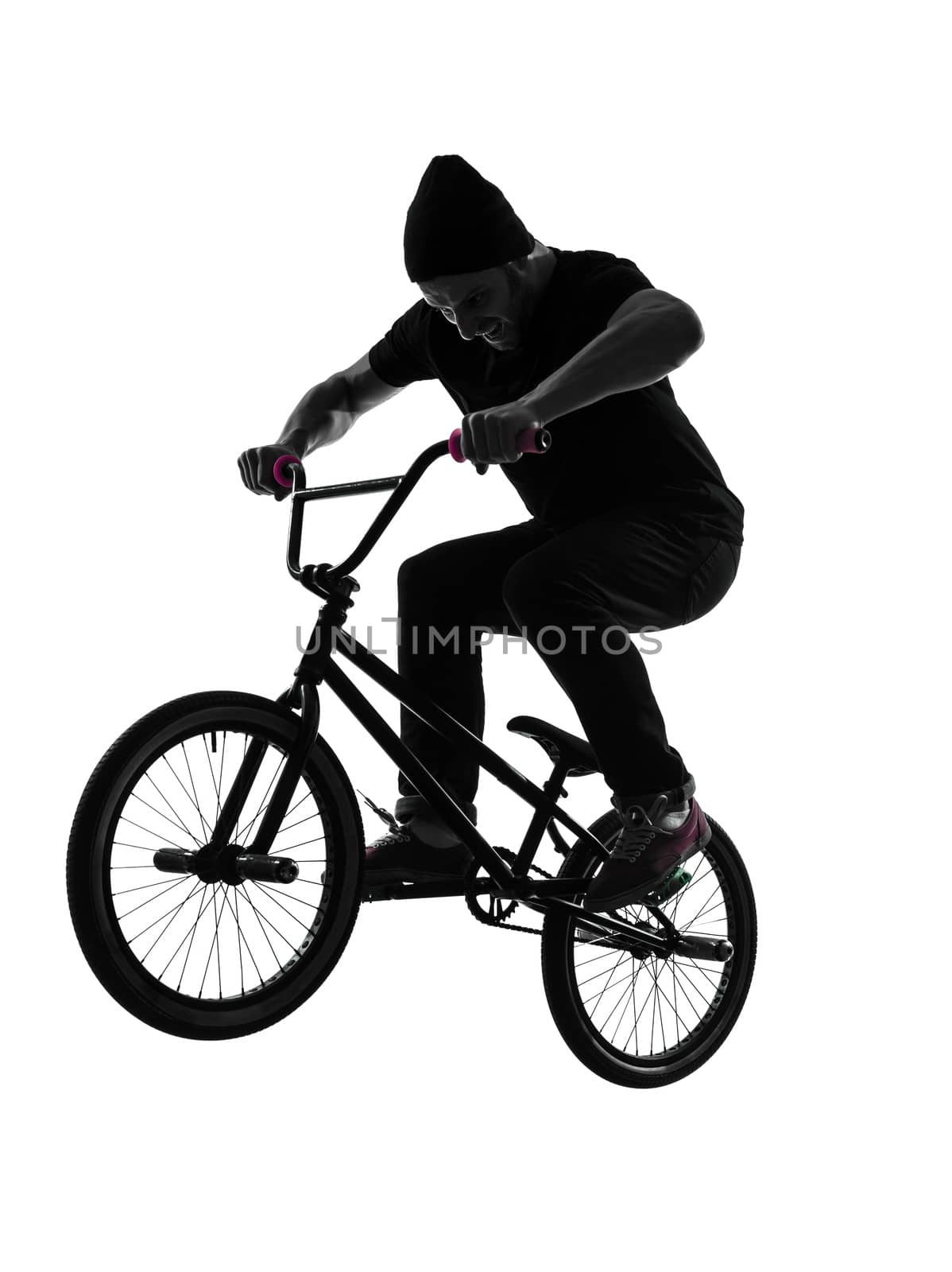 one caucasian man exercising bmx acrobatic figure in silhouette studio isolated on white background