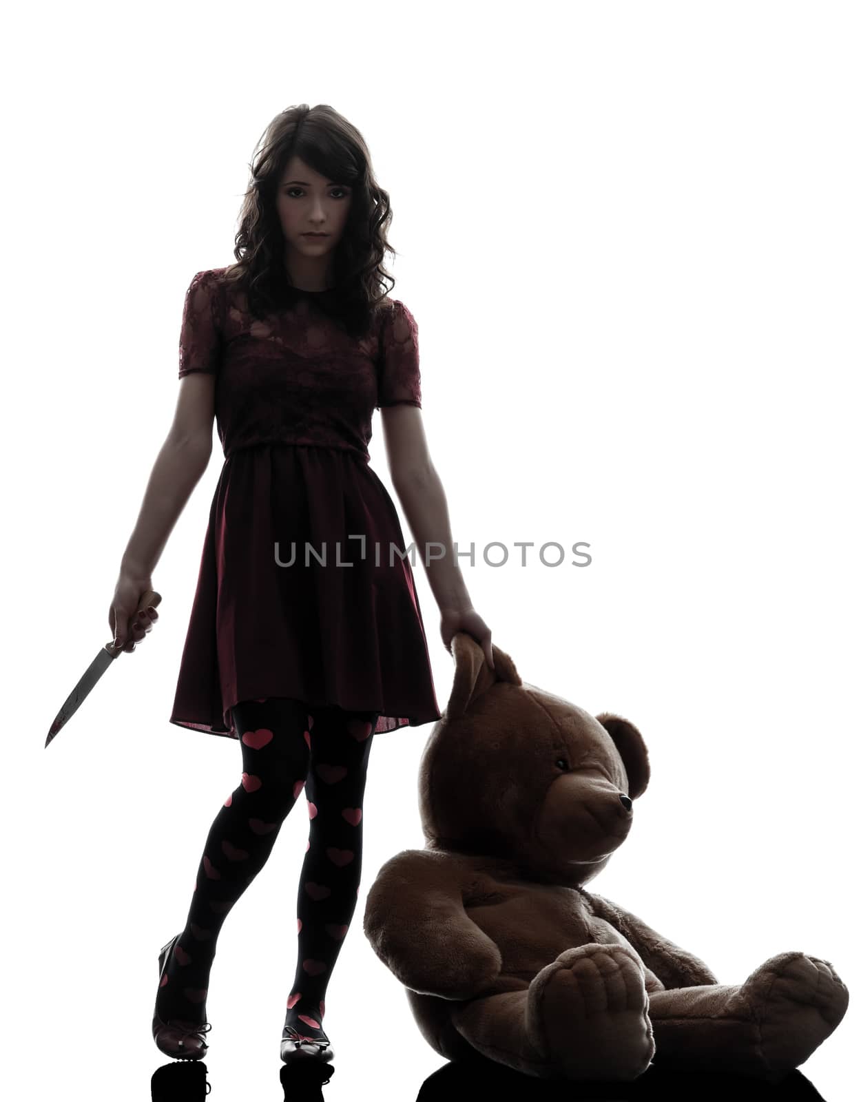 one caucasian strange young woman killer holding  bloody knife an teddy bear in silhouette white background