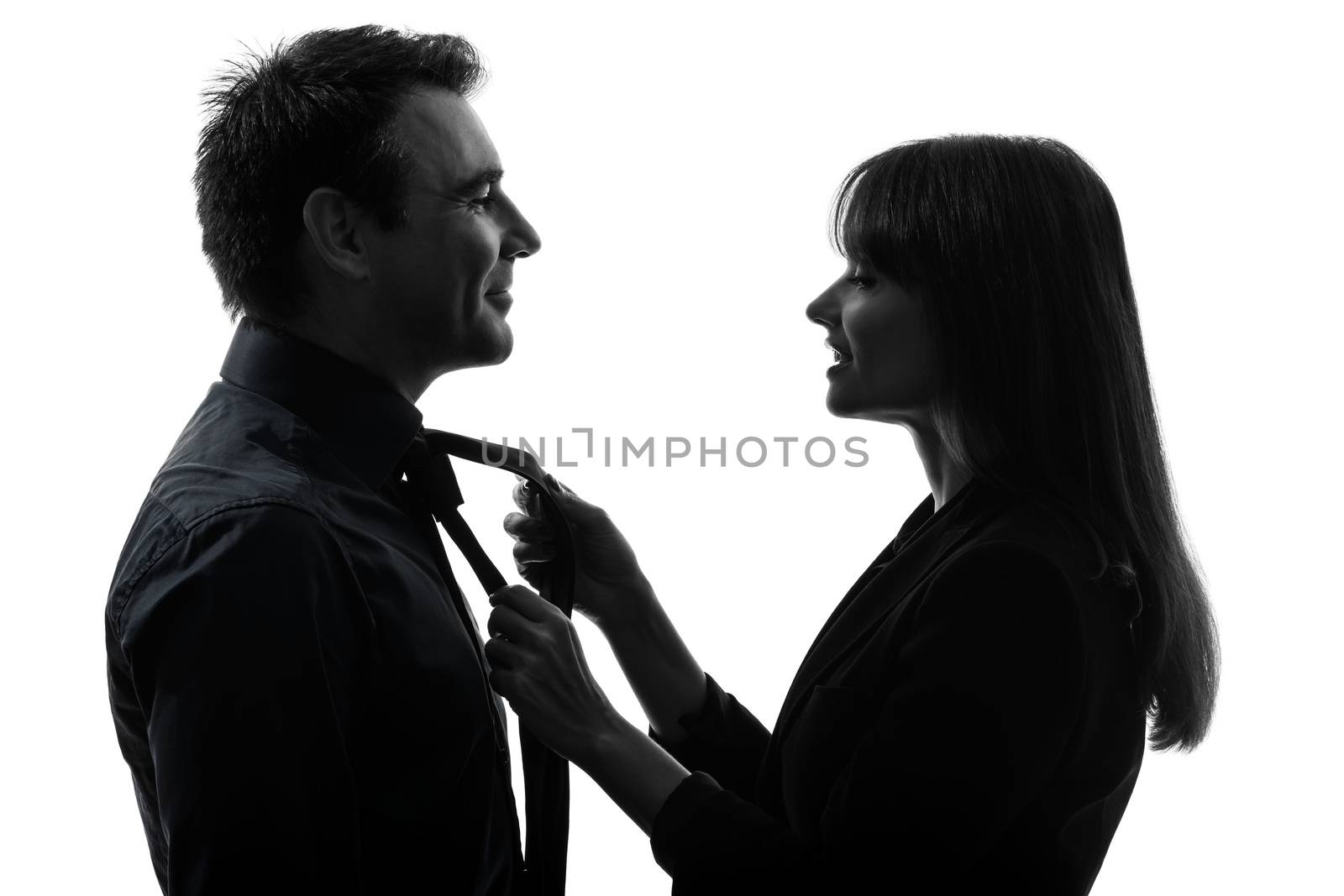 one caucasian couple woman helping man tying  in silhouette studio isolated on white background