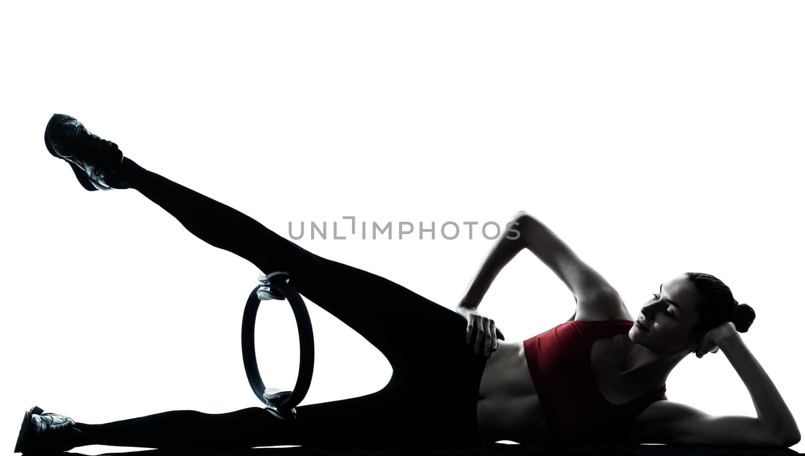 one caucasian woman exercising pilates ring in silhouette studio isolated on white background